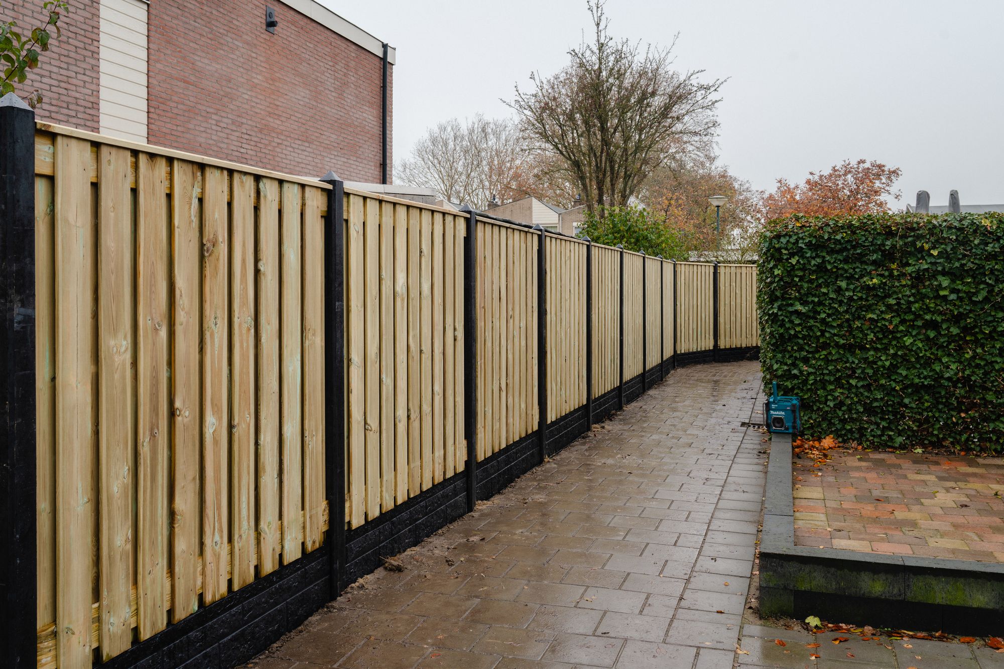 Nieuw geplaatste grenen schutting met antraciet betonpalen