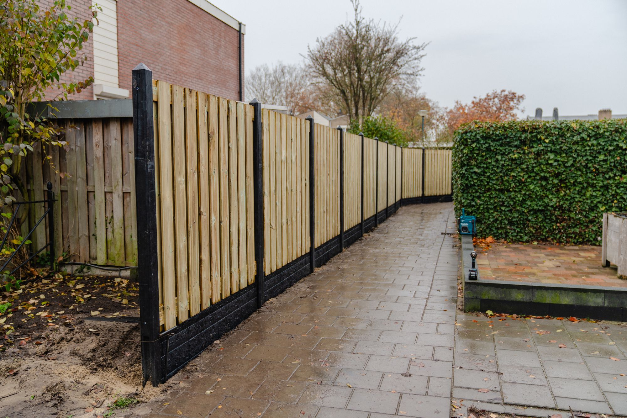 Nieuwe grenen schutting met antraciet betonpalen